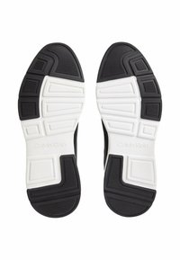 Sneakers Calvin Klein con suola esterna in gomma nera testurizzata e soletta bianca con scanalature e accenti. Logo impresso sul lato.