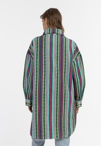 Daugiaspalvis marškiniai su dryžuotu raštu žalia, rožine, mėlyna ir balta spalvomis. Yra aukšta apykaklė ir mygtukai ant rankogalių.