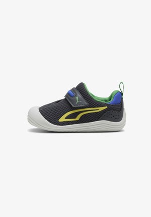 Scarpa da ginnastica per bambini in rete nera con striscia laterale gialla, fodera verde, inserti blu sul tallone, suola bianca e cinturino in velcro su sfondo bianco.