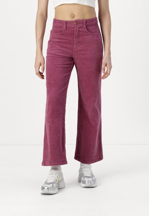 Pantaloni a gamba larga in corduroy rosa con vita alta, tasche frontali e chiusura con un solo bottone, caratterizzati da una texture a righe verticali.