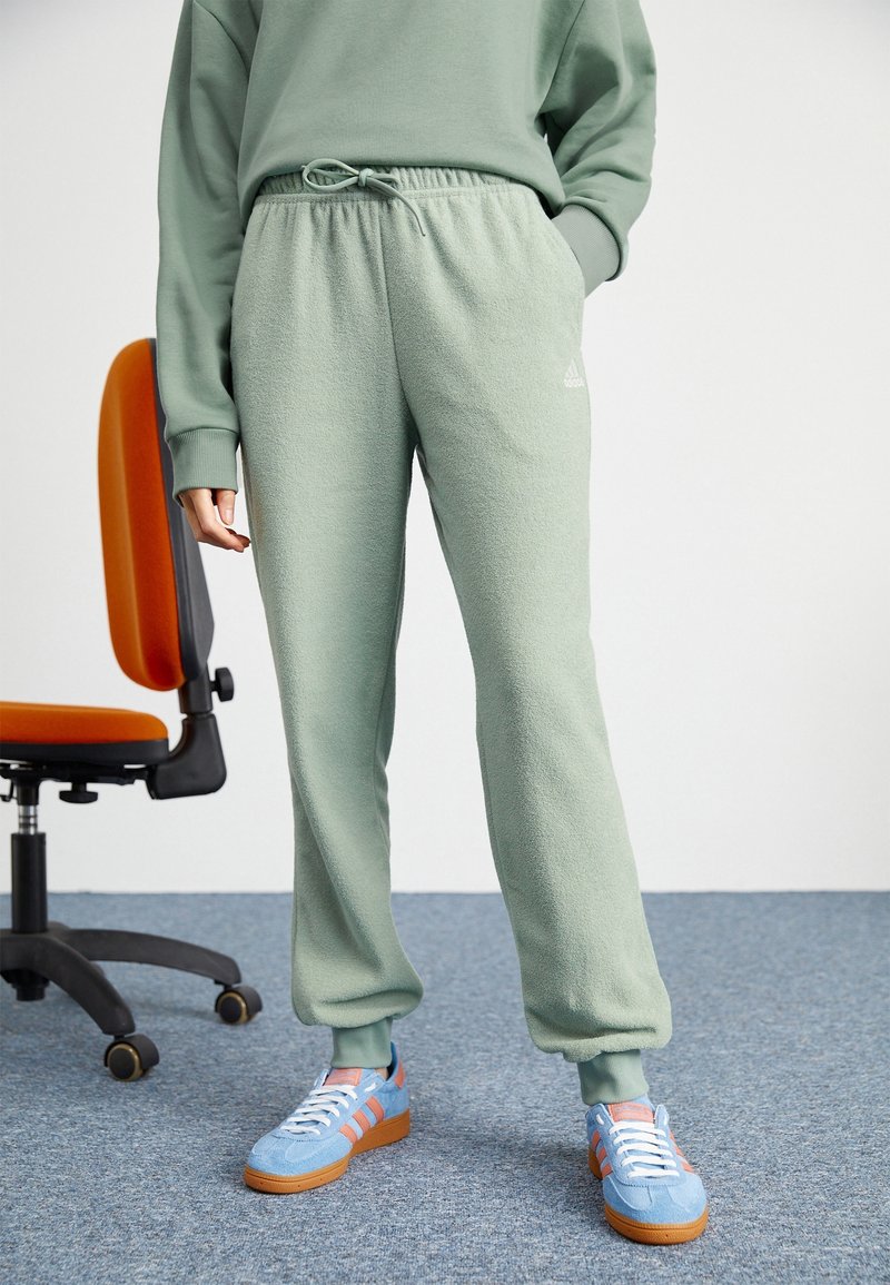 Gröna fleecebyxor med elastiskt midjeband och snörning; har sidofickor och subtil logotypdetalj på låret.