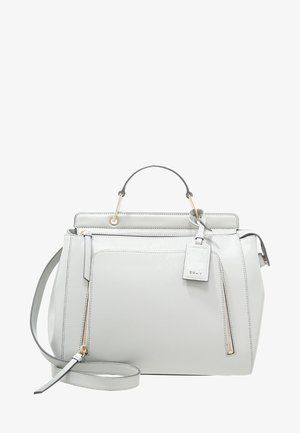Sac à main structuré en cuir blanc de DKNY avec poignée supérieure, bandoulière amovible, poches zippées à l'avant et étiquette de la marque.