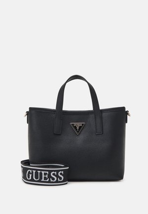 Svart faux skinn veske med doble topphåndtak, har et gulltriangel-logo og en avtagbar stropp med "GUESS" i hvitt. Enkel design.
