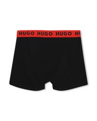 Μαύρα αντρικά μποξεράκια με κόκκινη μέση που φέρει επαναλαμβανόμενο κείμενο "HUGO" σε μαύρο, παρουσιάζονται σε λευκό φόντο.