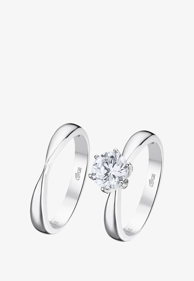 Two silver rings. One features a round, clear gemstone set in a multi-prong setting; the other has a smooth, twisting band design.