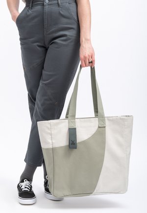 Canvas draagtas in beige en saliegroen met een gladde textuur, voorzien van een twee-kleurig ontwerp en een gestikt handvat.