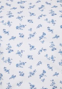 Vit tyg med ett upprepande blommönster i olika nyanser av blått, med små rosor och blad i en fin, slumpmässig uppställning.