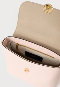 Ροζ δερμάτινη τσάντα με χρυσό στρογγυλό κούμπωμα. Στο εσωτερικό διαθέτει τσέπη με φερμουάρ και μπεζ φόδρα με ετικέτα επωνυμίας. Ομαλή υφή.