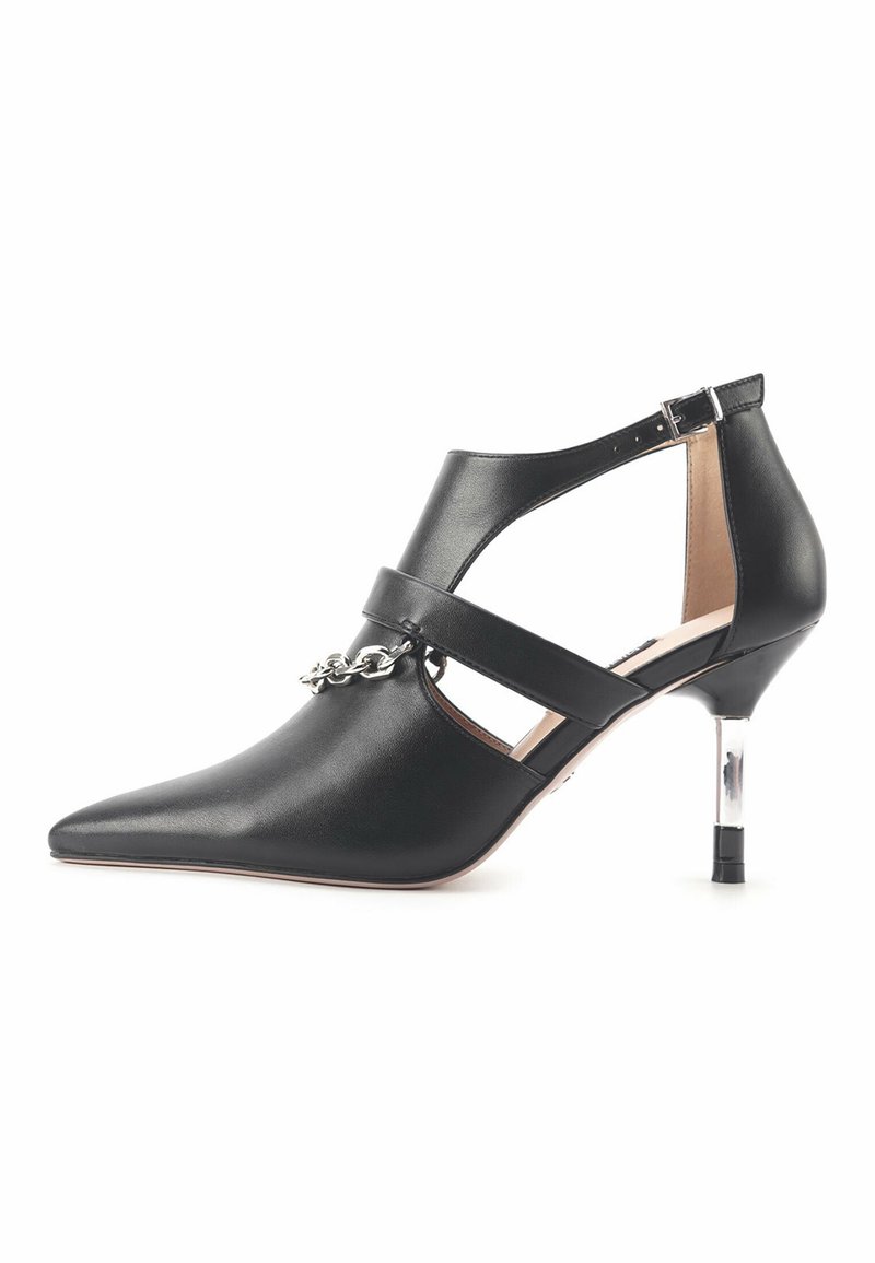 Escarpin noir à bout pointu avec bride à la cheville, détail chaîne argentée et talon fin transparent sur fond blanc.
