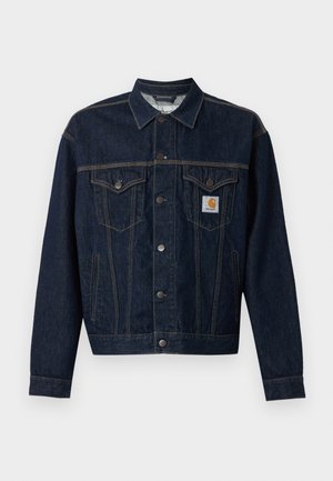 Dunkelblaue Denimjacke mit Knopfverschluss, zwei Brustklappentaschen, Seitentaschen und einem kleinen Carhartt-Logo-Patch auf der linken Brusttasche.