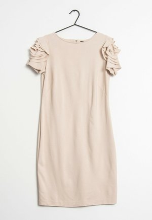 Robe beige à manches courtes avec encolure ronde et détails de volants superposés sur les manches, suspendue sur un cintre noir.