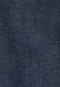 Mørkeblå denimstof med synligt diagonalt vævemønster og små hvide prikker over det hele.