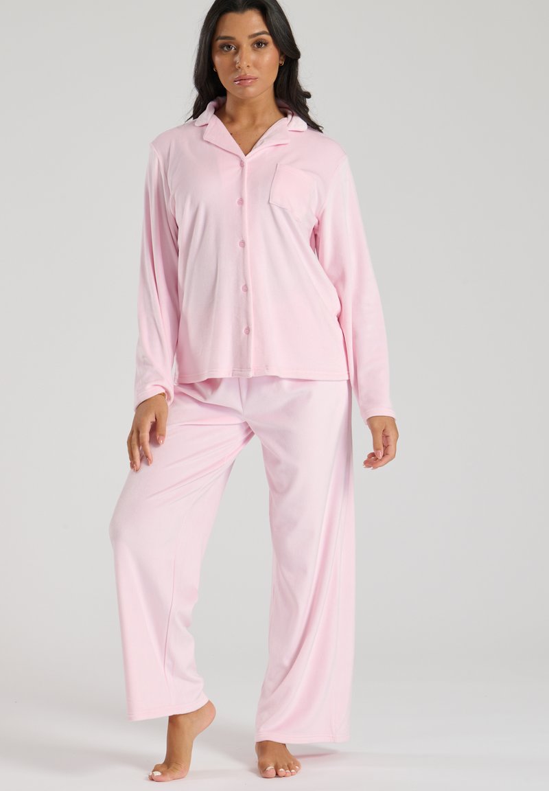 Sættes pyjamas i lys pink, lavet af blødt stof. Langærmet skjorte med knaplukning, krave og brystlomme; løse bukser.