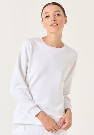 Weißes Sweatshirt mit Rundhalsausschnitt, langen Ärmeln und gerippten Bündchen. Weiche, glatte Textur mit lockerer Passform und seitlichen Schlitzen am Saum.