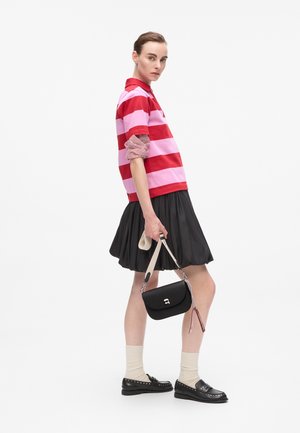 Red and pink striped polo shirt, black pleated skirt, black shoes, cream socks, and a small black handbag with a silver clasp detail.