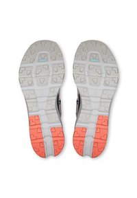 Scarpe sportive con parte superiore grigia. Suola esterna scolpita presenta sezioni bianche e color corallo chiaro con motivi testurizzati per aderenza e stabilità.