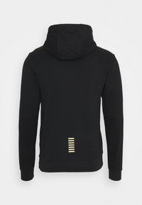 Svart sweatshirt med huva, med en upphöjd bakre nederkant och en guldfärgad randdetalj i nedre mitten. Tillverkad av ett mjukt, texturerat tyg.
