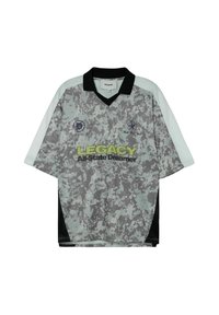 Szary i czarny sportowy t-shirt z krótkim rękawem w wzór kamuflażu, z czarnym kołnierzykiem i żółtym napisem "LEGACY" z przodu.