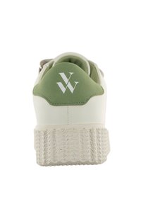 Sneaker blanc avec un accent vert au talon et une semelle en caoutchouc texturée. Caractérisé par un logo blanc à l'arrière et une tige lisse en synthétique.