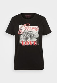 Czarny bawełniany t-shirt z graficznym nadrukiem, na którym znajdują się słowa "Guess" w czerwonym kolorze oraz "LOVE" w pogrubionej czerwieni z kwiatowym wzorem poniżej.