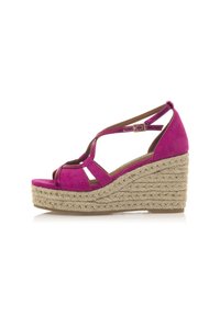 Sandali con zeppa in suede rosa, con punta aperta, cinghie incrociate e fibbia regolabile alla caviglia. La piattaforma intrecciata in juta aggiunge consistenza e altezza.