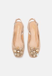 Beige suede slingback ballerina's met decoratieve juwelen bloemenversieringen op de tenen en verstelbare zilveren gespen op de banden.
