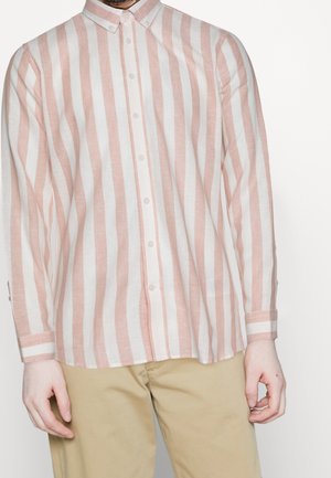 Chemise en lin à boutons avec des rayures verticales roses et blanches, manches longues et col classique. Fermeture à boutons à l'avant et détails aux poignets.