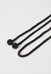 Black beaded necklace with two spherical ends. Smooth, cylindrical beads create a textured surface. Dimensions and clasp not visible.