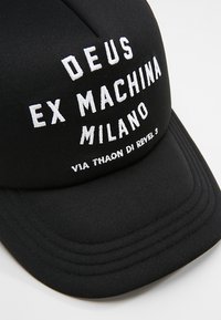 Cappellino da baseball nero con testo ricamato bianco che recita "DEUS EX MACHINA MILANO" e "VIA THAON DI REVEL 3" sul davanti.