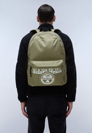 Olivgrüner Rucksack mit einer Fronttasche, ausgestattet mit einem weißen Logo und Text. Hergestellt aus strapazierfähigem Material, verfügt er über verstellbare Träger und einen oberen Griff.