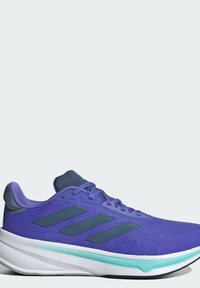 Zapatilla de running morada con una parte superior de malla texturizada, detalles en azul oscuro, logo de tres rayas y suela blanca con un detalle en verde menta.