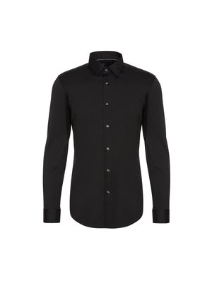 Chemise noire à manches longues en tissu lisse, avec un col pointu, une patte de boutonnage centrale et des poignets à fermetures à bouton.
