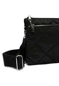 Sac bandoulière matelassé noir en nylon avec des accessoires en argent, doté d'une poche zippée à l'avant et d'une sangle ajustable durable.