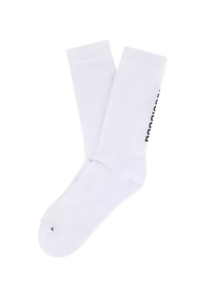 Para białych skarpet za kostkę z prążkowanymi ściągaczami i czarnym napisem logo na boku, oznaczona literą "L" w okolicy palców.