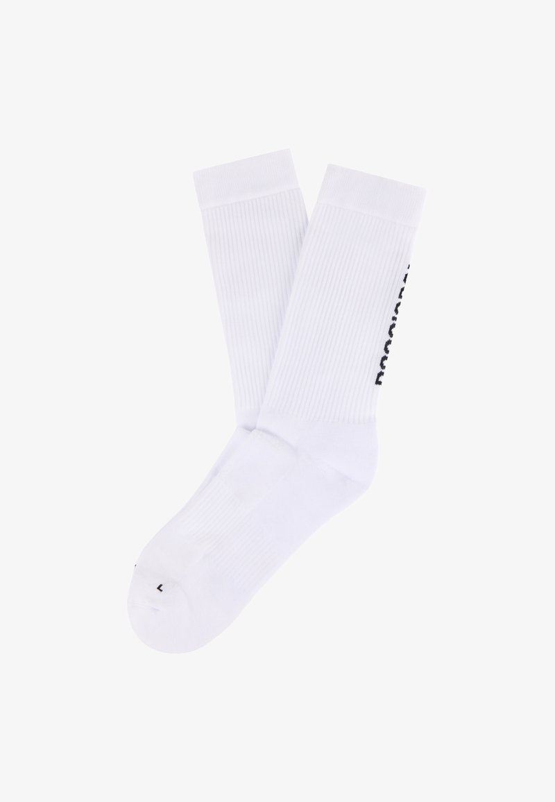Paire de chaussettes blanches montantes avec des bords côtelés et un logo texte noir sur le côté, marquées d'un "L" sur la zone des orteils.