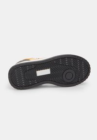 Zwarte rubberen sneakerzool met een gestructureerd patroon, voorzien van een rechthoekige uitsparing en een ronde verhoogde zone. Duurzaam materiaal met een antislipontwerp.