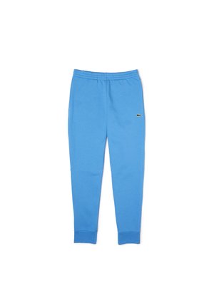 Pantalon de survêtement bleu clair en tissu mélangé coton, avec une taille élastique et des poignets de cheville, arborant un petit logo sur le côté.