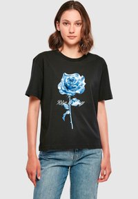 Sort bomulds t-shirt med et stort blåt rosen grafik og teksten "Rise & Stay" nedenfor. Korte ærmer og en afslappet pasform.
