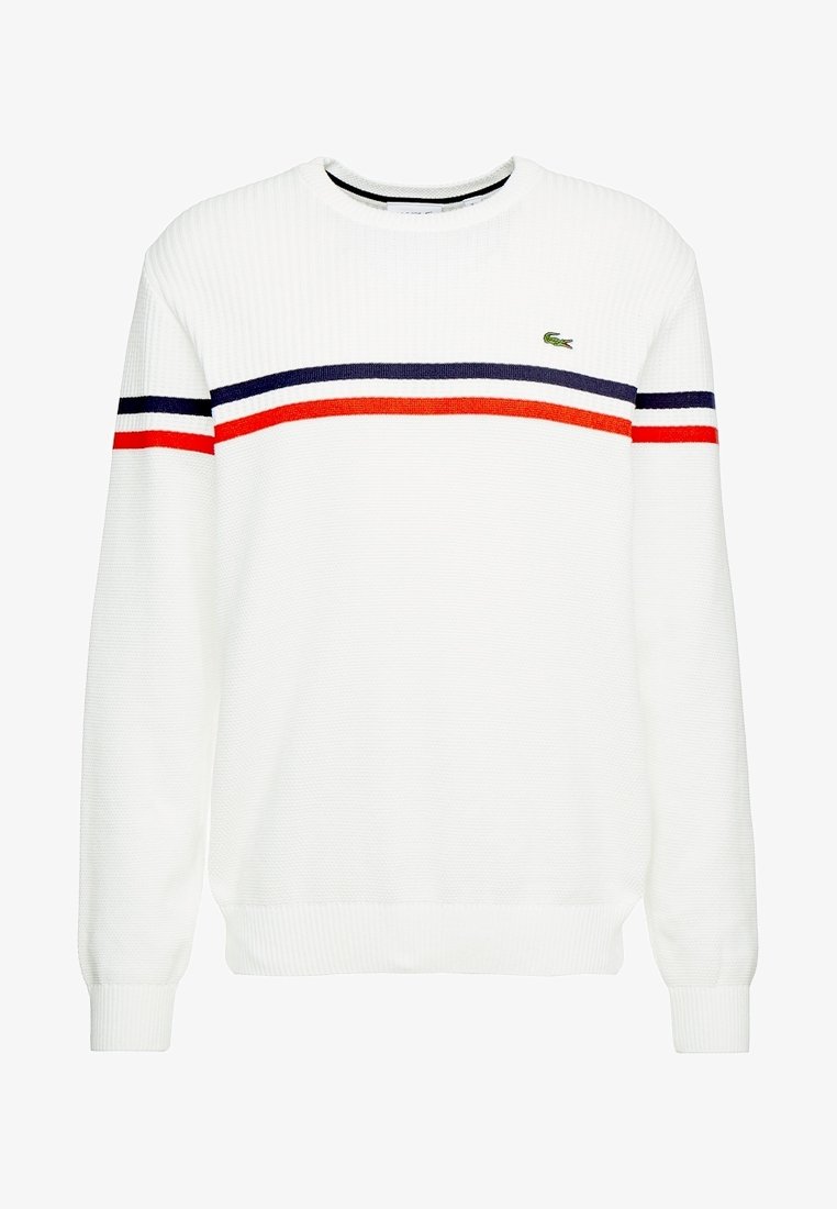 Pull blanc à col rond avec des rayures horizontales bleu marine et rouge sur la poitrine et les manches, avec un petit logo crocodile vert sur la poitrine gauche.