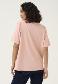 Roze katoenen t-shirt met een relaxte pasvorm en korte mouwen. Het heeft een ronde halslijn en een subtiele logo-detail nabij de zoom.