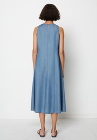 Denim ermeløs kjole, A-linje silhuett, lys blå farge, nøkkelhull bakdetalj, søm langs armhulene og hem, ankel lengde.