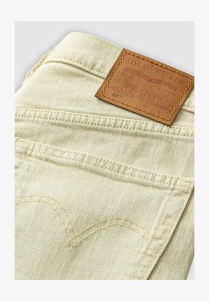 Levi's 501 Jeans aus hellem beigen Denim mit einem Lederetikett, klassischen Nähten und zwei Gesäßtaschen.