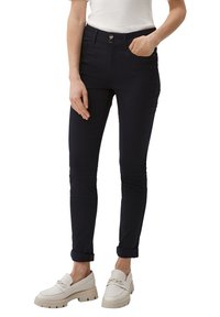 Pantalon bleu marine en tissu extensible avec une coupe slim, un design à cinq poches et une fermeture à bouton. Manches retroussées et détails de couture sur les côtés.