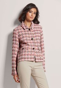 Tweed jacket in roze met een geweven patroon en multikleurige accenten. Het heeft een kraag, knopen aan de voorkant en twee zijzakken.