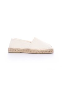 Espadrilles de lona blanca con suela de cuerda de yute, que presentan un diseño sin cordones y puntera afilada. Textura suave y acentos de costura mínimos.