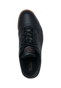 Scarpa sportiva in pelle nera con design perforato, punta tonda, lacci neri e suola in gomma marrone con dettagli testurizzati.