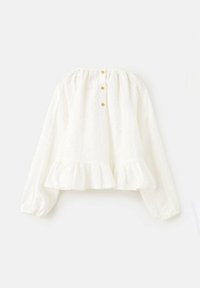 Bílá halenka s dlouhým rukávem z texturované látky, s volánkovým lemem a zapínáním na knoflíky vzadu. Jednoduchý a volný střih.