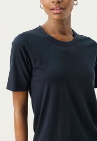 Námořnické tričko s krátkými rukávy, kulatým výstřihem a hladkým bavlněným materiálem, s jednoduchým designem bez ozdob nebo vzorů.