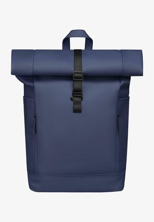 Tumši zils rullējošais mugursoma, izgatavota no gluda materiāla. Iespējas ietver melnu siksnu aizdari, sānu rāvējslēdzējus un iecirstu zīmola logotipu apakšā.