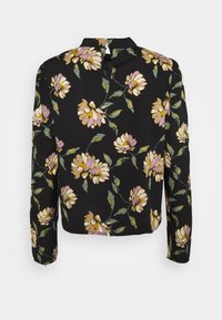Blusa nera floreale con maniche lunghe, caratterizzata da fiori gialli e lavanda, foglie verdi e un dettaglio a chiave sul retro. Tessuto dalla texture liscia.